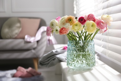 Photo of Beautiful ranunculus flowers in vase on window sill indoors, space for text