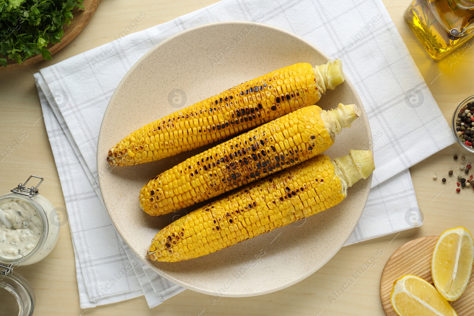 Photo of Flat lay composition with tasty grilled corn on wooden table