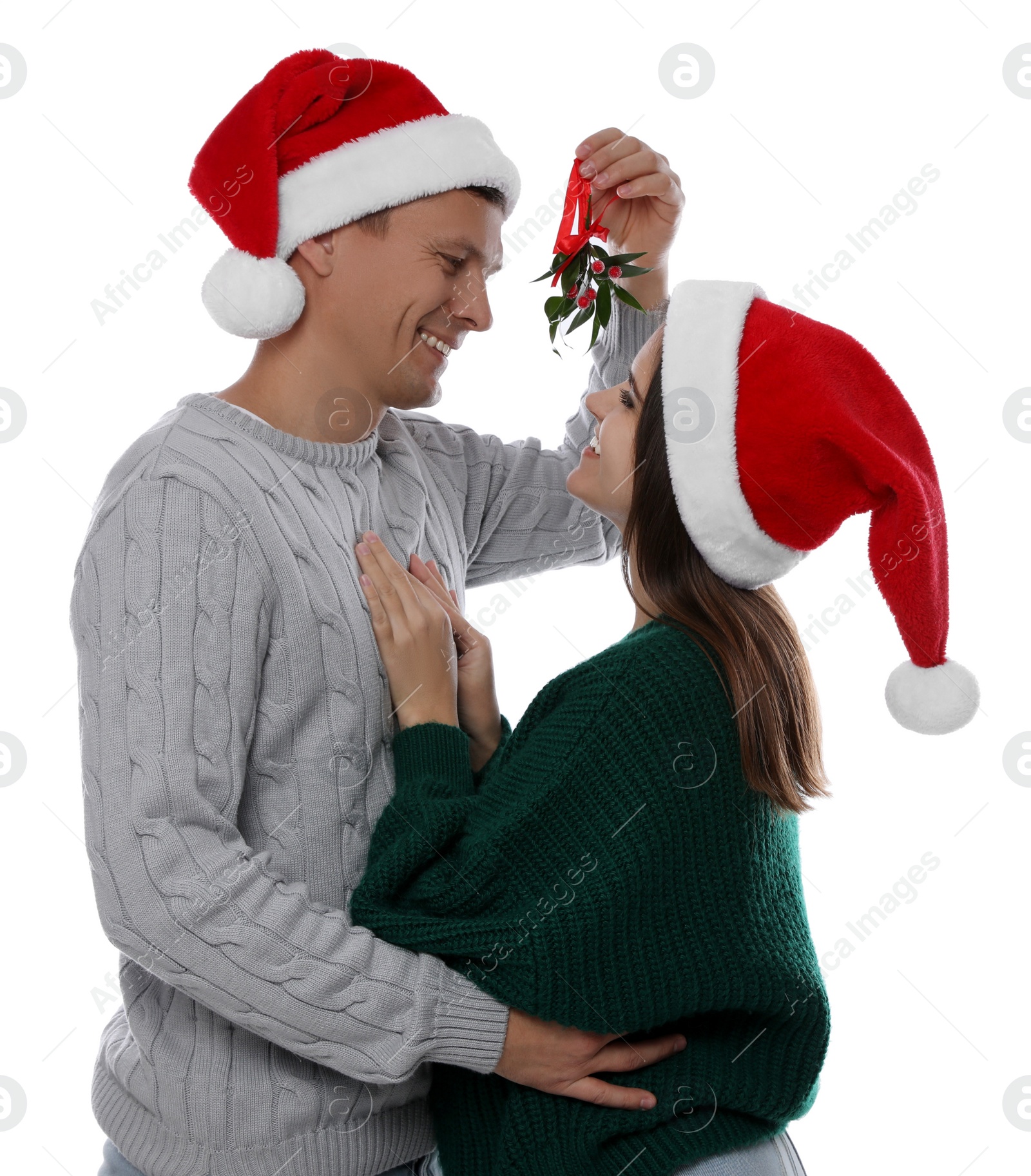 Photo of Happy couple standing under mistletoe bunch on white background