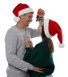 Photo of Happy couple standing under mistletoe bunch on white background