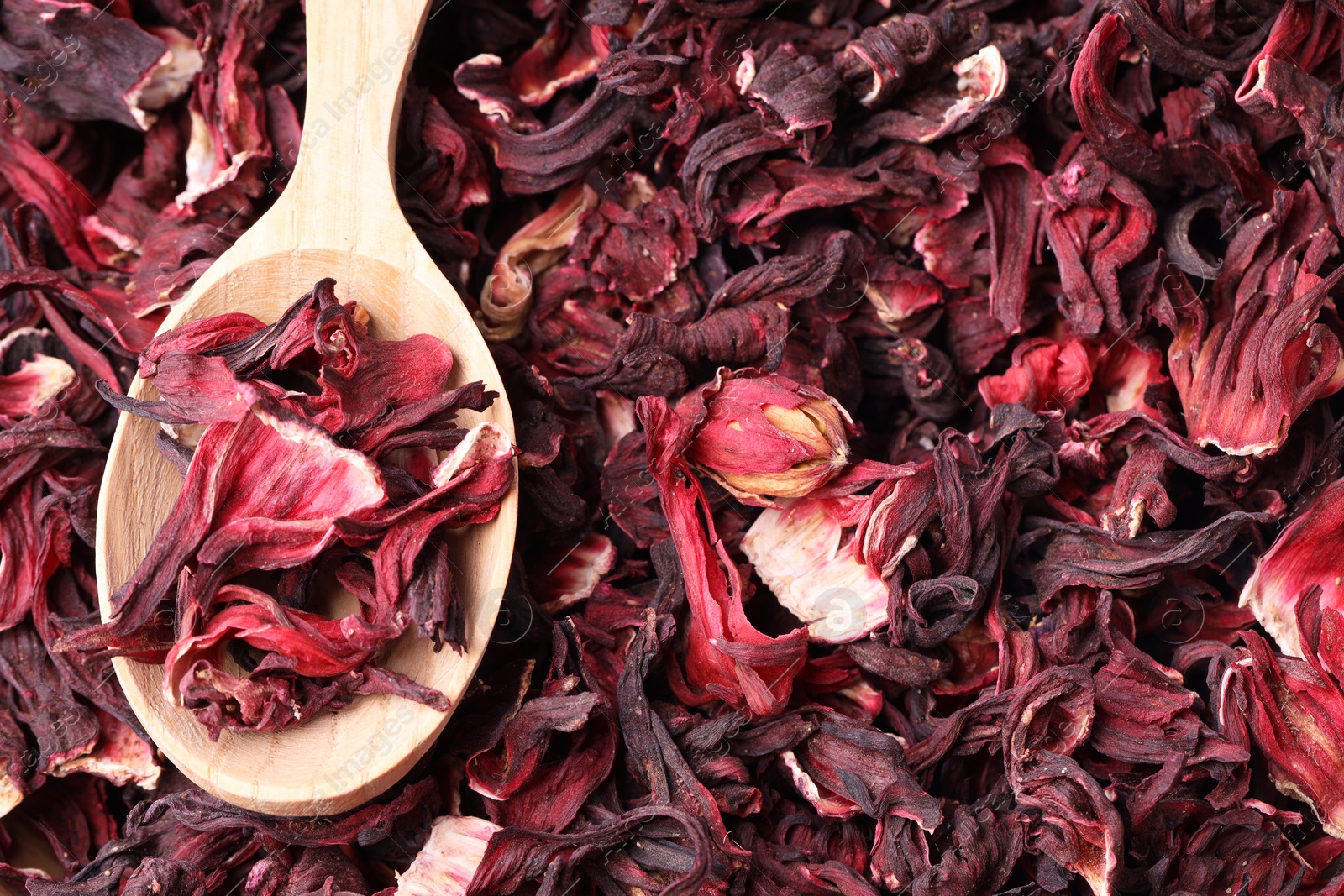 Photo of Wooden spoon with dry hibiscus tea, closeup