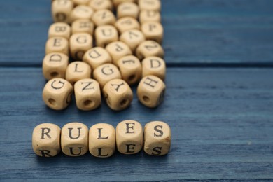 Word Rules made of cubes with letters on blue wooden table