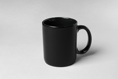 Photo of Black ceramic mug on light grey background