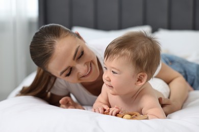 Photo of Happy mother with her baby on bed at home