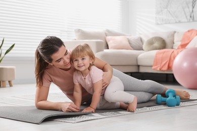 Photo of Mother doing exercise with her daughter at home