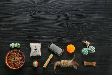 Flat lay composition with cat accessories and food on dark wooden background