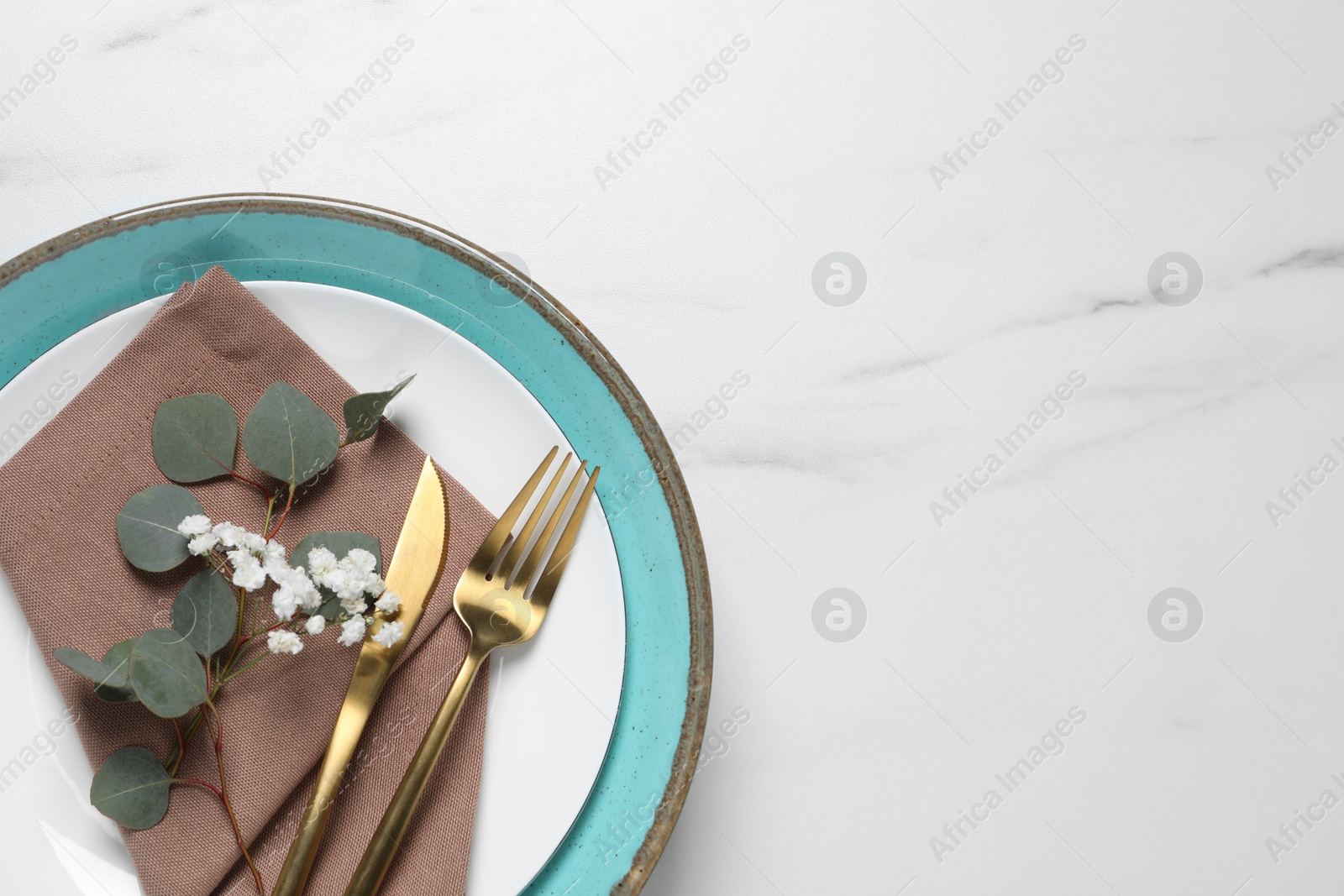 Photo of Stylish table setting with cutlery, flower and eucalyptus leaves, top view. Space for text