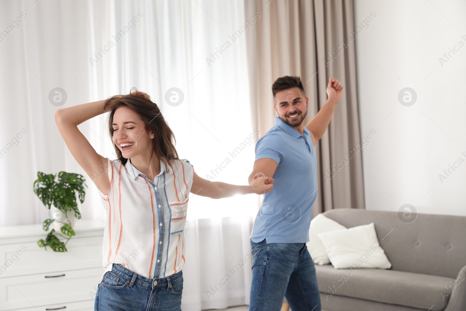 Photo of Lovely young couple dancing together at home