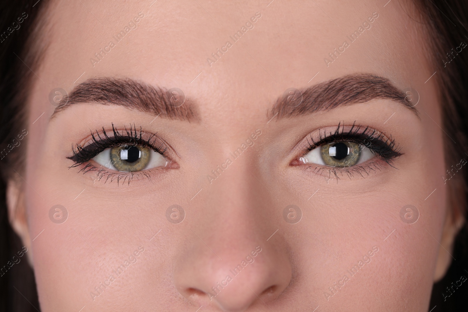 Photo of Young woman after permanent makeup procedure, closeup