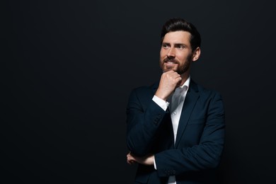 Photo of Portrait of handsome bearded man looking away on black background. Space for text