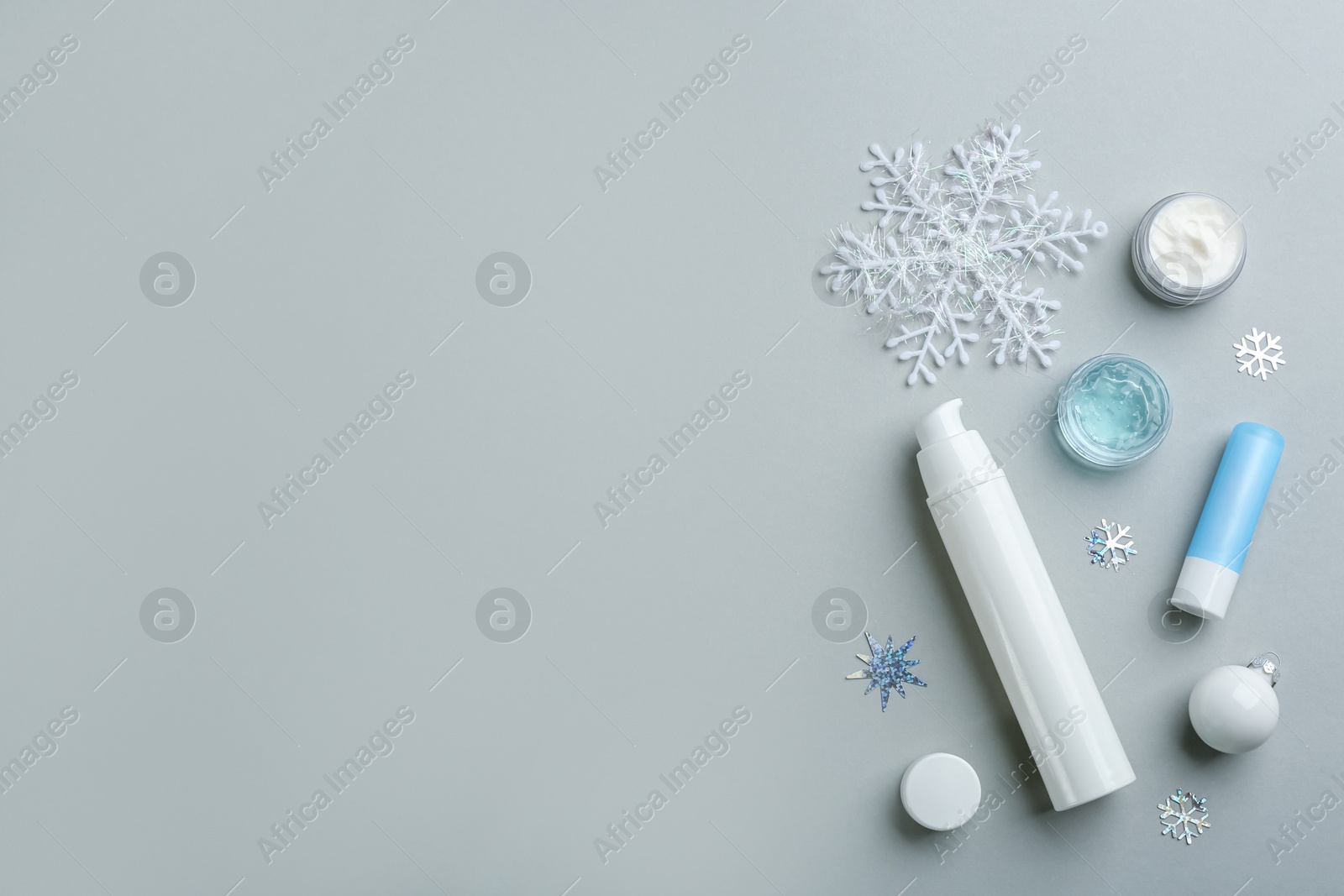 Photo of Flat lay composition with different cosmetic products on light grey background, space for text. Winter care