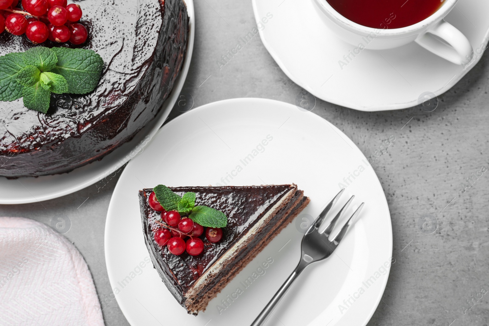 Photo of Tasty chocolate cake with berries on grey table, flat lay