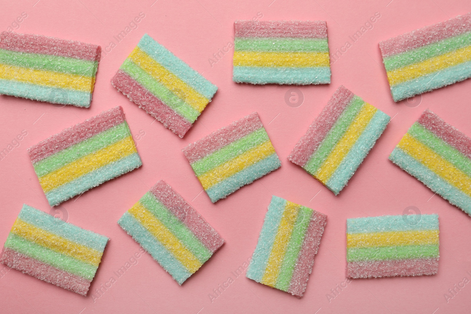 Photo of Delicious gummy candies on pink background, flat lay