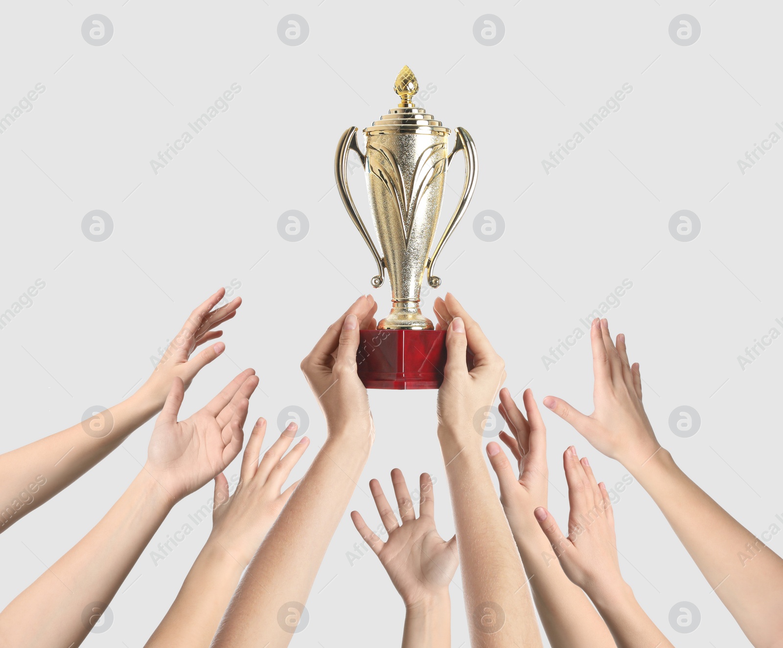 Image of People with golden trophy cup on light background, closeup