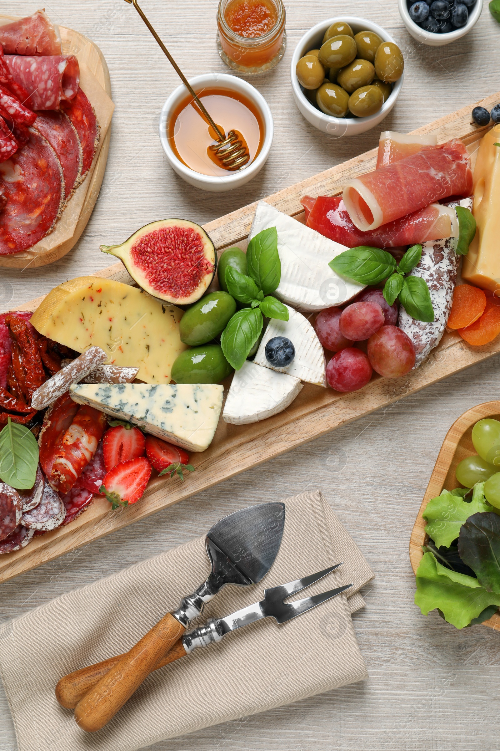 Photo of Set of different delicious appetizers served on white wooden table, flat lay