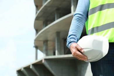 Professional builder with safety equipment at construction site, space for text