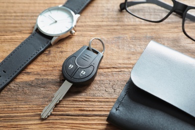 Photo of Composition with male accessories and car key on wooden background