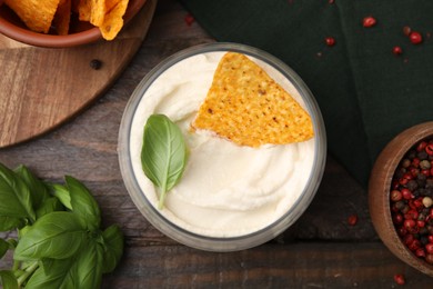 Delicious tofu sauce served with nachos chip on wooden table, flat lay