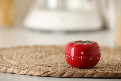 Kitchen timer in shape of tomato on table indoors. Space for text
