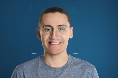 Image of Facial recognition system. Man with scanner frame and digital biometric grid on blue background