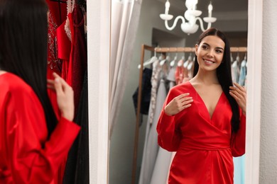Photo of Woman trying on dress in clothing rental salon