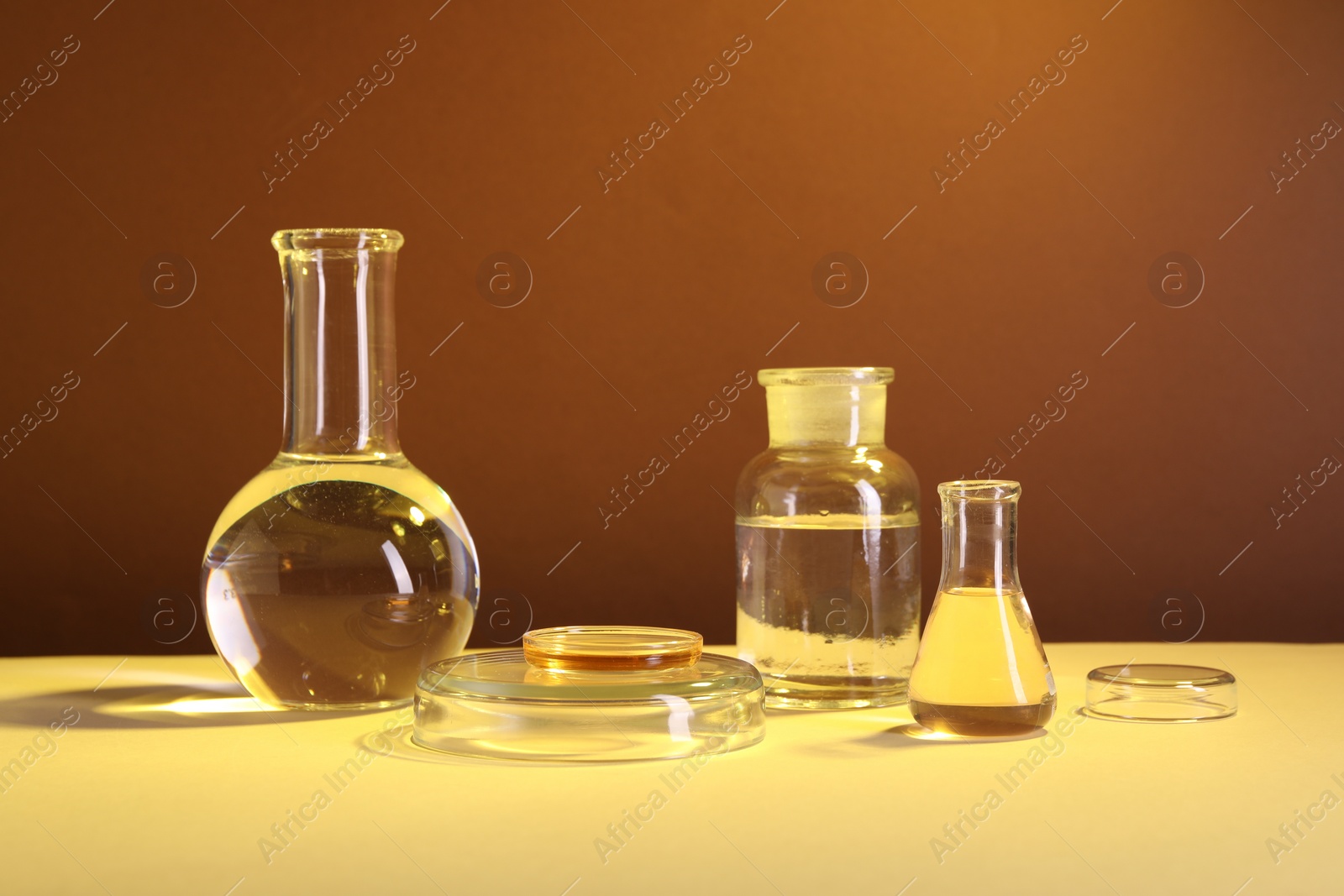 Photo of Laboratory analysis. Different glassware on table against brown background