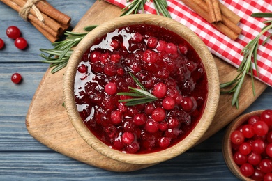 Photo of Flat lay composition with cranberry sauce and rosemary on blue wooden table
