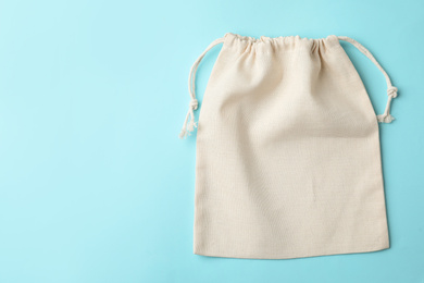 Cotton eco bag on light blue background, top view. Space for text