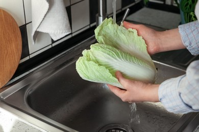 Photo of Woman washing fresh Chinese cabbage in sink, closeup