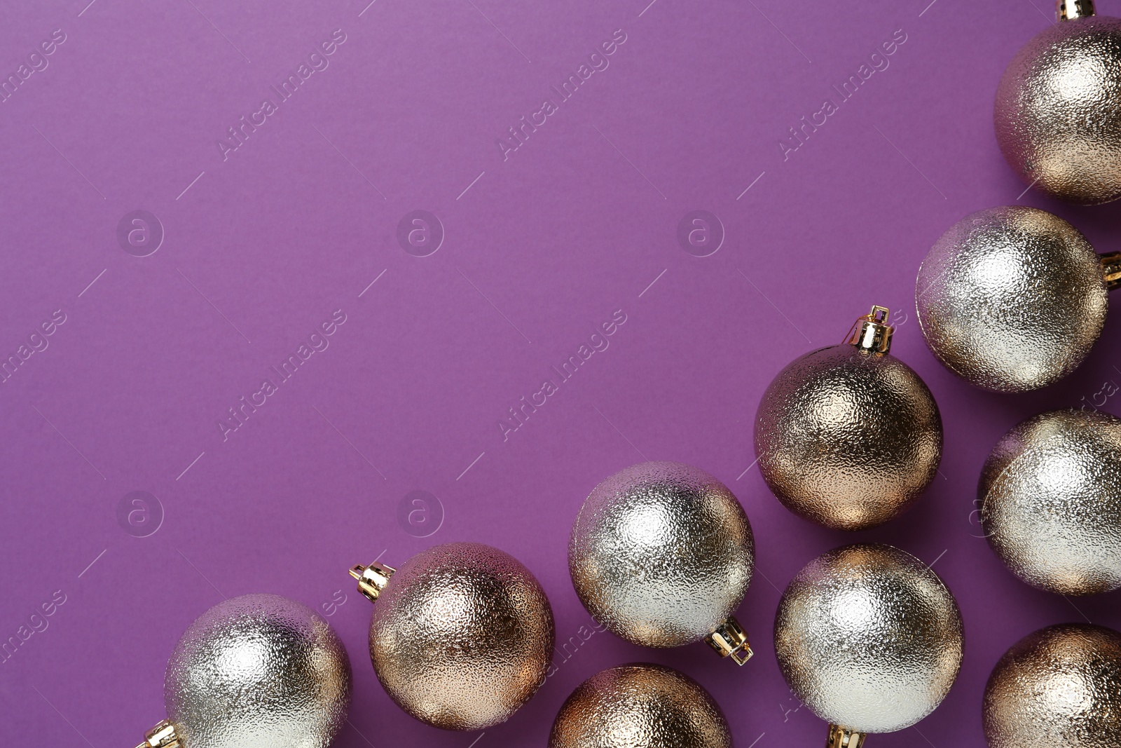 Photo of Many shiny Christmas balls on purple background, flat lay with space for text