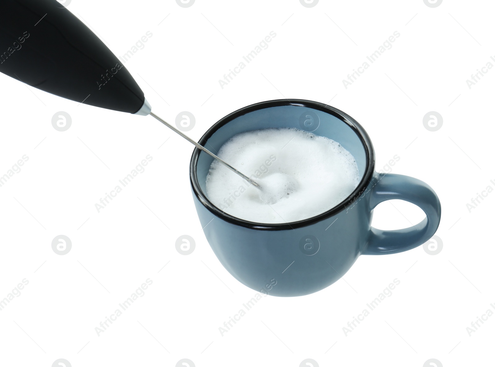 Photo of Whisking milk in cup with mini mixer (frother wand) isolated on white, closeup