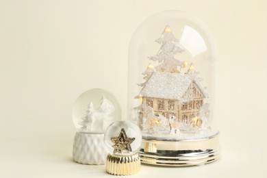 Photo of Different beautiful snow globes on beige background