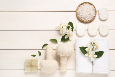 Photo of Flat lay composition with spa stones and beautiful jasmine flowers on white wooden table, space for text