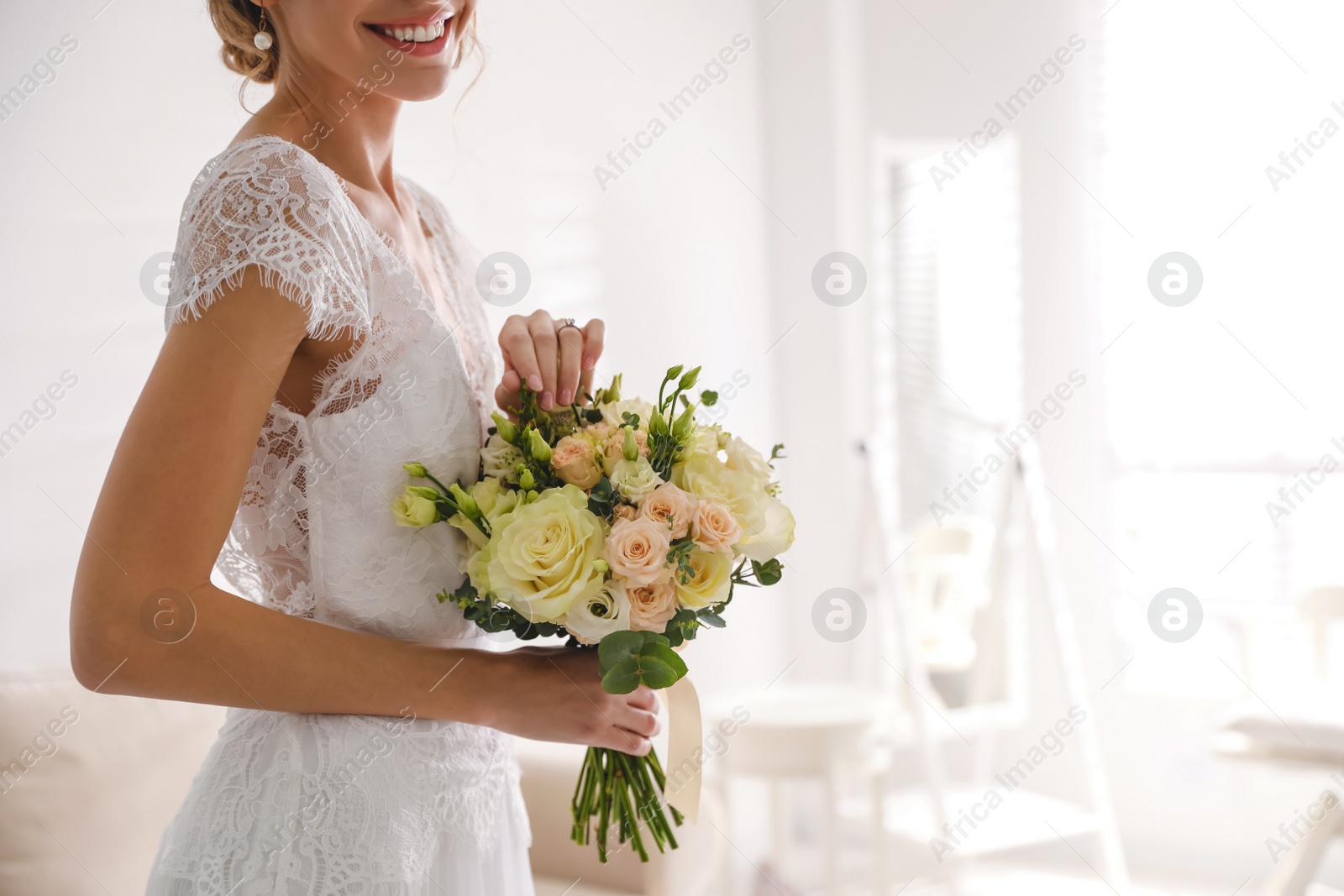 Photo of Young bride with beautiful wedding bouquet in room, closeup. Space for text