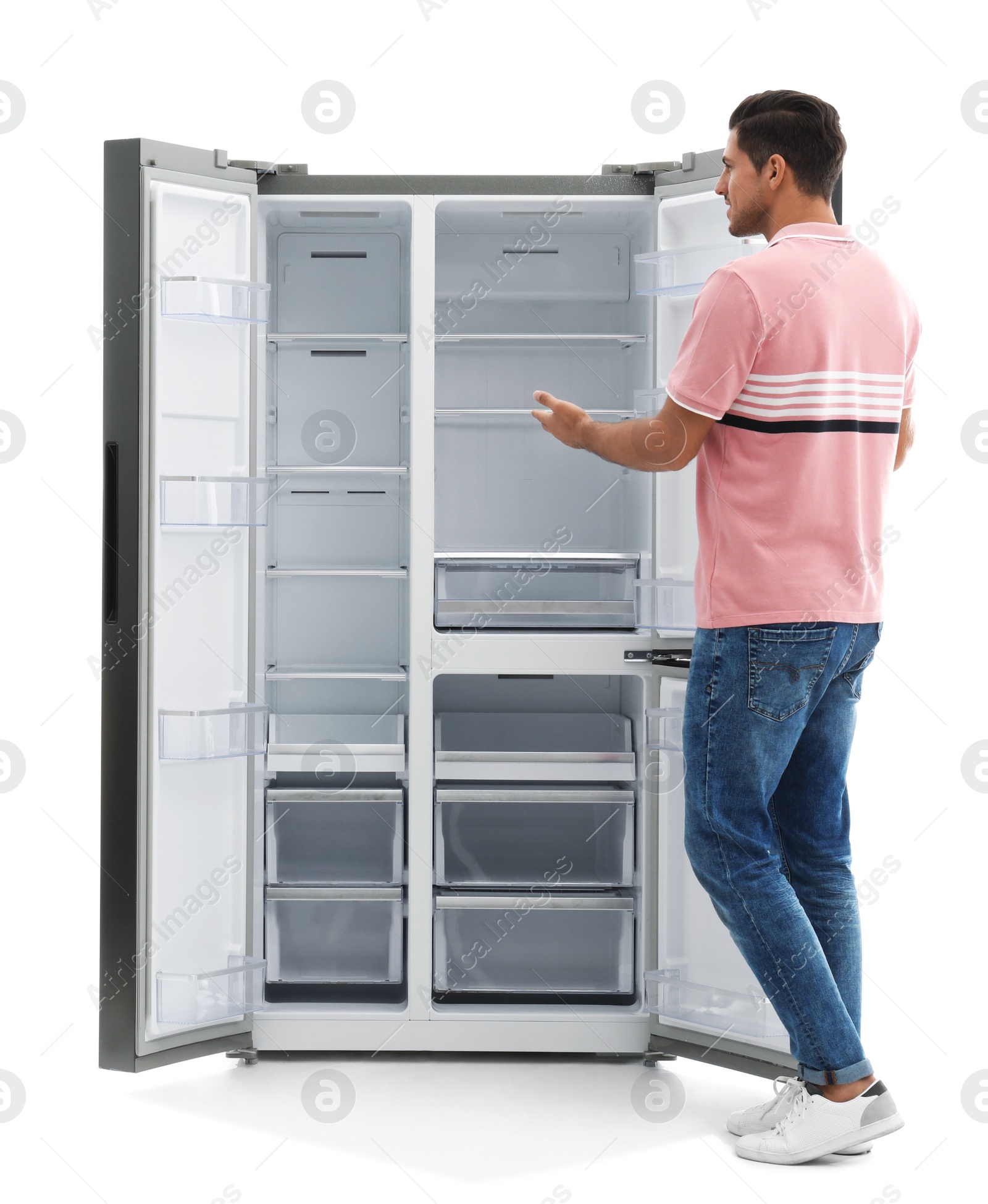 Photo of Man near empty refrigerator on white background