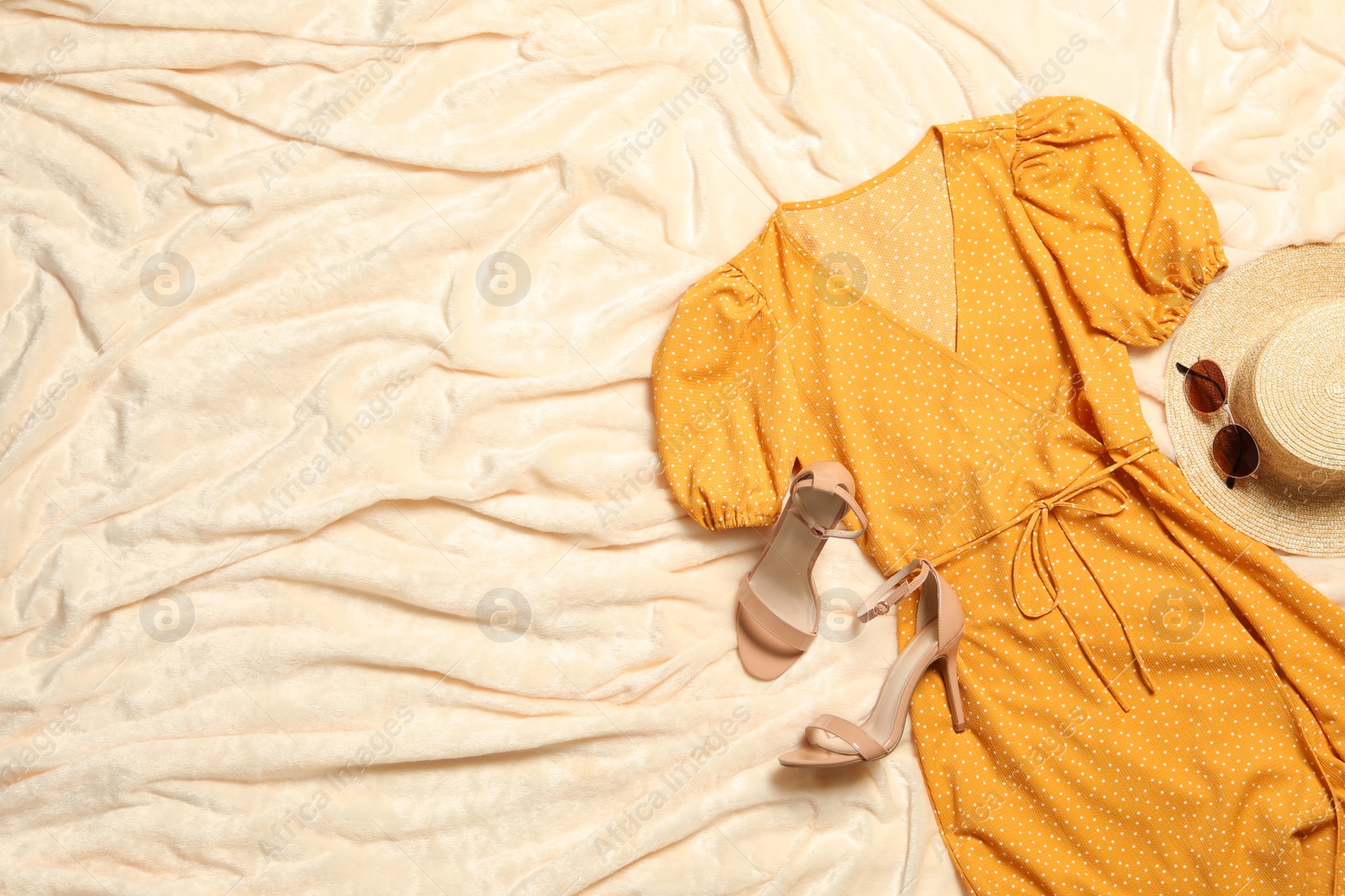 Photo of Flat lay composition with stylish yellow dress on beige blanket. Space for text