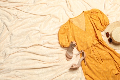 Photo of Flat lay composition with stylish yellow dress on beige blanket. Space for text