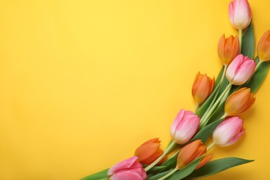 Photo of Beautiful tulips on yellow background, flat lay. Space for text