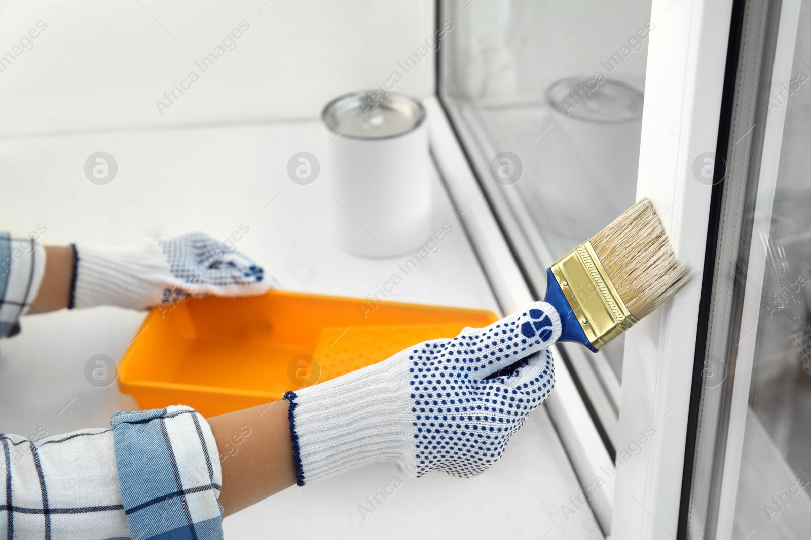 Photo of Woman painting window frame at home, closeup