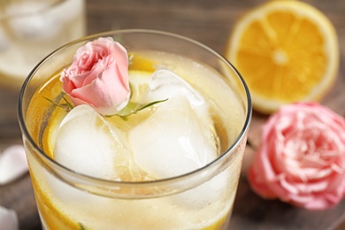 Delicious refreshing drink with lemon and rose, closeup