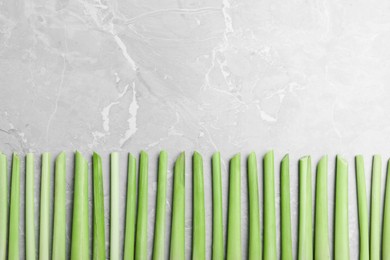Fresh lemongrass stalks on light grey marble table, flat lay. Space for text