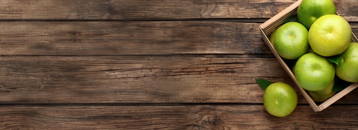 Image of Fresh ripe sweetie fruits in crate on wooden table, flat lay with space for text. Banner design