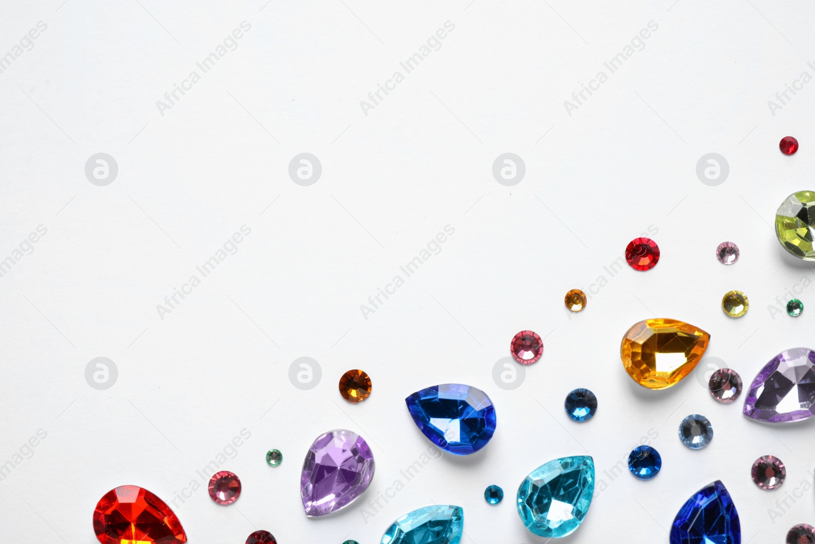 Photo of Different beautiful gemstones on white background, top view