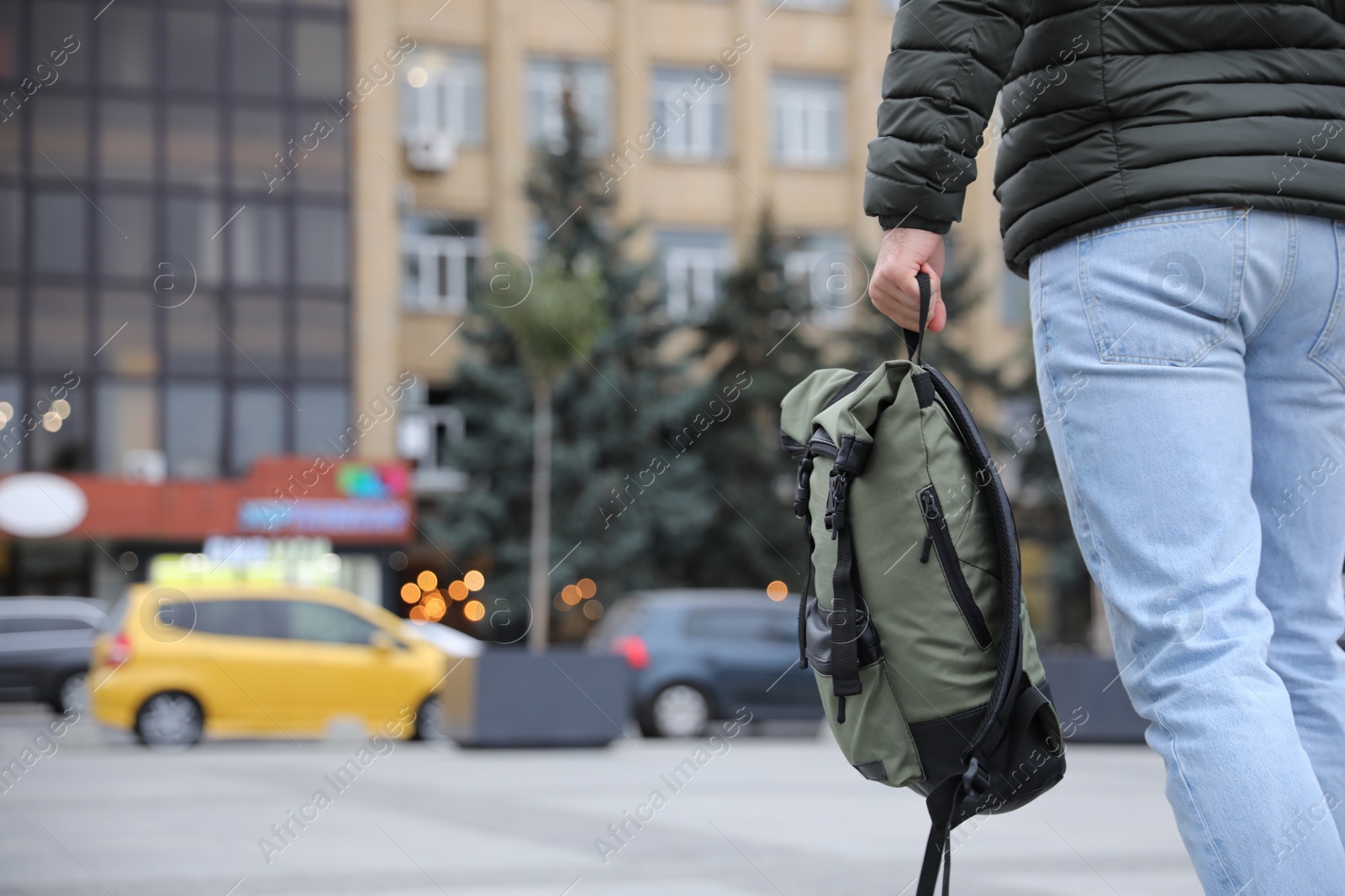 Photo of Male tourist with travel backpack on city street, closeup. Urban trip