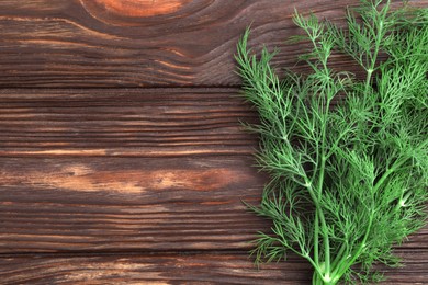 Photo of Fresh dill on wooden table, top view. Space for text