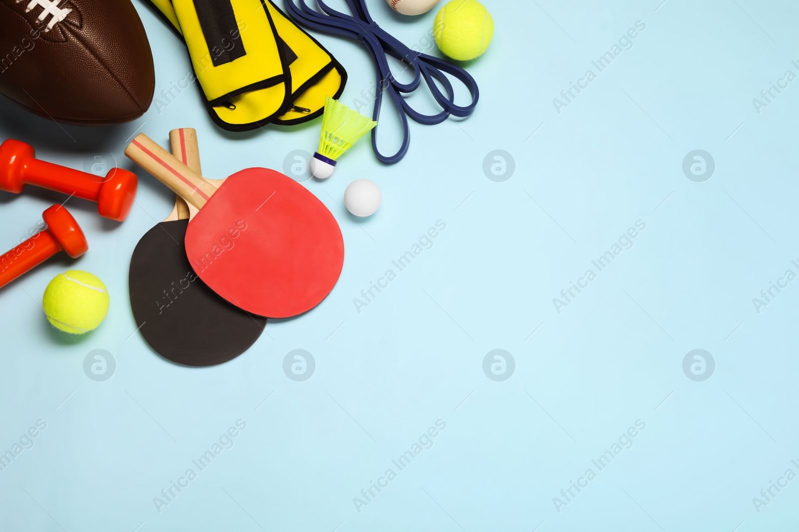 Photo of Set of different sports equipment on light blue background, flat lay. Space for text