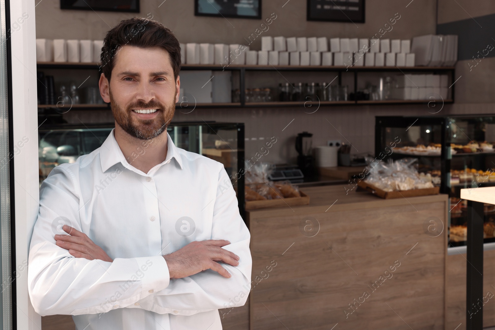 Photo of Happy business owner in bakery shop. Space for text