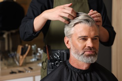 Photo of Hair styling. Professional hairdresser working with client in barbershop, closeup