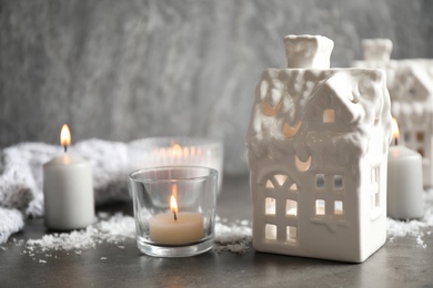 Photo of Composition with house shaped candle holders on grey stone table. Christmas decoration