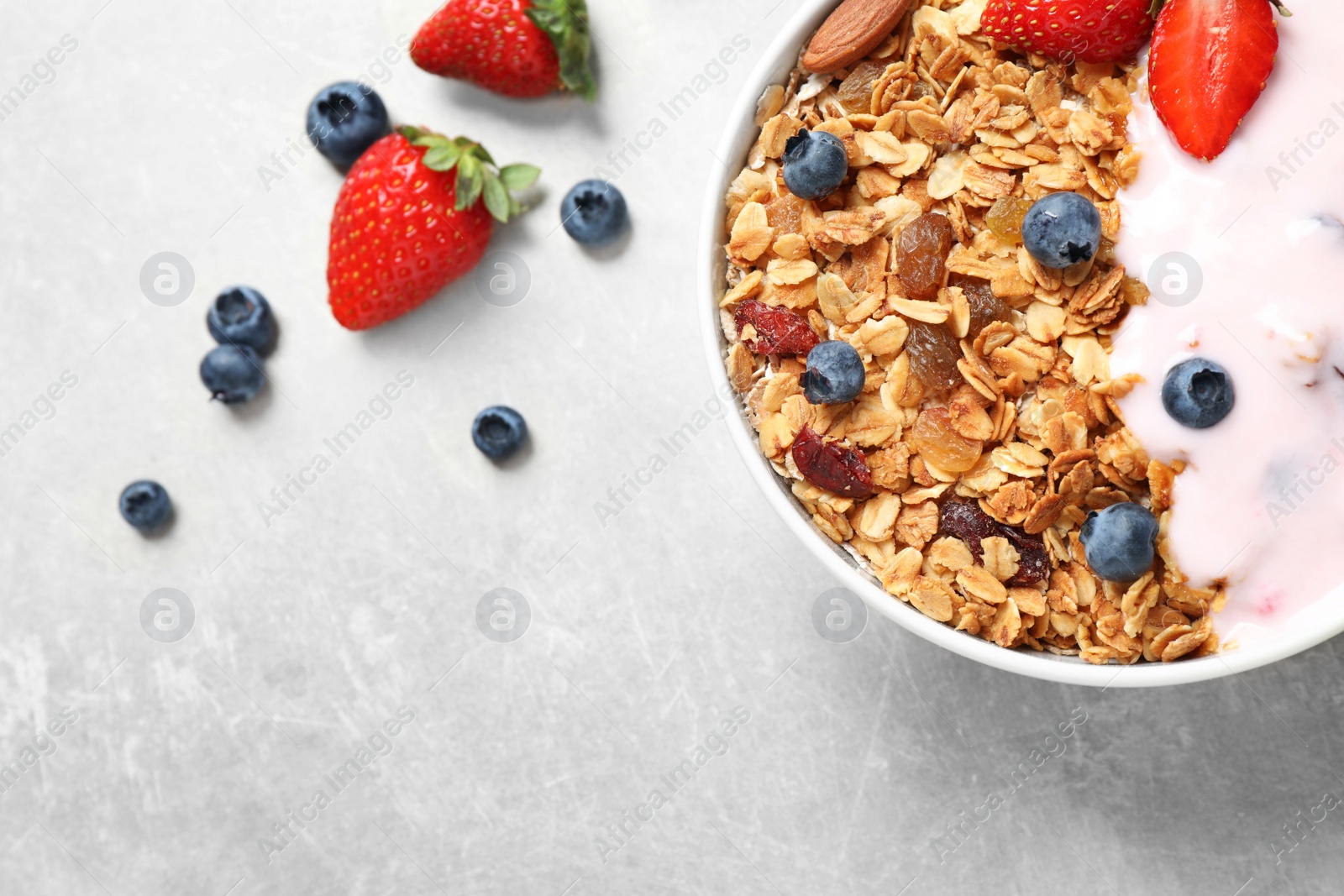 Photo of Tasty homemade granola served on grey table, flat lay. Healthy breakfast